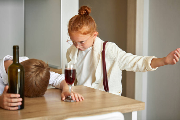 child alcoholism. little boy drinking alcohol at home - 写真・画像