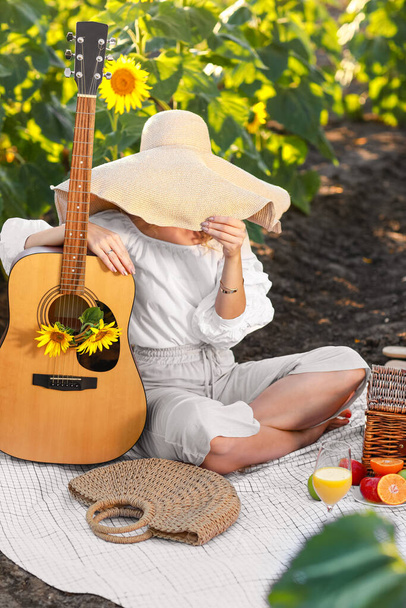 Hermosa joven con guitarra en campo de girasol - Foto, imagen