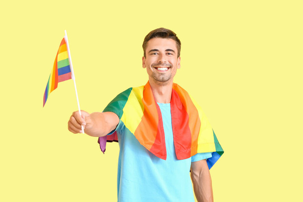 Jongeman met LGBT vlaggen op kleur achtergrond - Foto, afbeelding