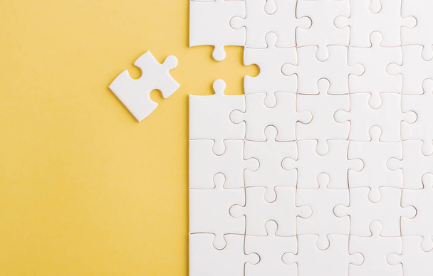 Top view flat lay of paper plain white jigsaw puzzle game texture last pieces for solve and place, studio shot on a yellow background, quiz calculation concept - Zdjęcie, obraz