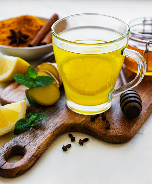 Energy tonic drink with turmeric, ginger, lemon and honey on a white marble background - Photo, Image