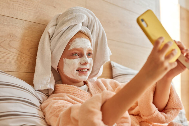 adorable caucasian kid girl take selfie on bed - Valokuva, kuva