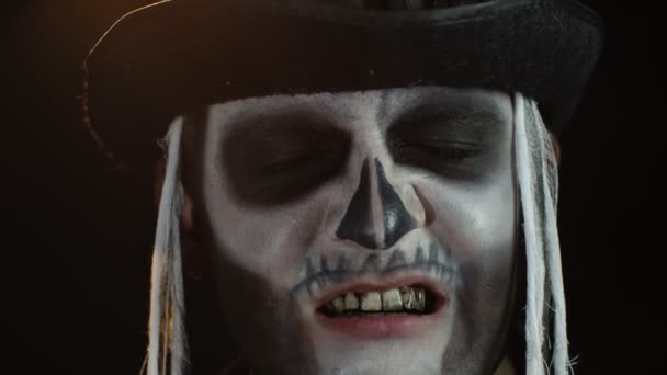 Άνθρωπος με σκελετό ανατριχιαστικό μακιγιάζ προσπαθεί να τρομάξει, ανοίγοντας το στόμα του και δείχνοντας βρώμικα μαύρα δόντια - Πλάνα, βίντεο