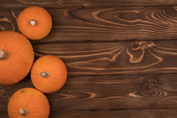 Autumn small orange pumpkin on a wooden table, the harvest, the symbol of Halloween - Fotoğraf, Görsel