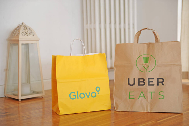 WŁOCHY - Mediolan październik 30,2019 - Uber Eats and Glovo delivery food - order food from the restaurant and eat in home - Zdjęcie, obraz