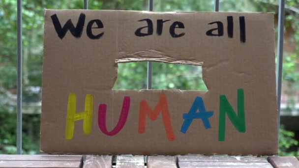 Amerika, VS - blank latijns meisje met bord "We are all human" protest en manifest. Begrip racisme en sociaal geweld   - Video