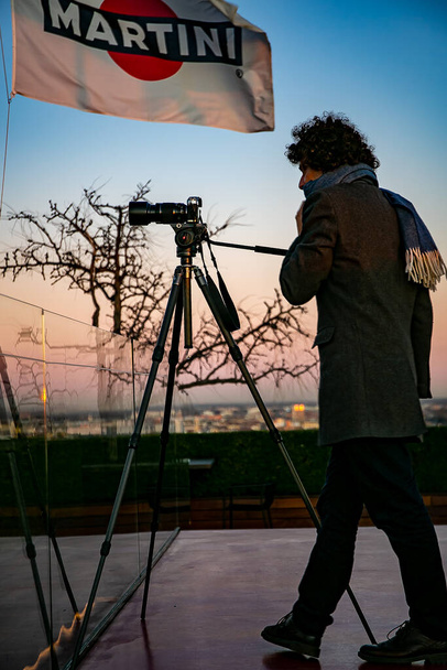 Italia, Milano joulukuu 14,2019 - Valokuvien ottaminen ja videoiden tekeminen valokuvajalustalla Martini Terracen katolta auringonlaskun aikana - Valokuva, kuva