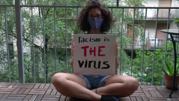 Amerika USA - bílá latinskoamerická dívka s nápisem "Rasismus je virus" protestuje a projevuje se. Koncept rasismu a sociálního násilí  - Záběry, video