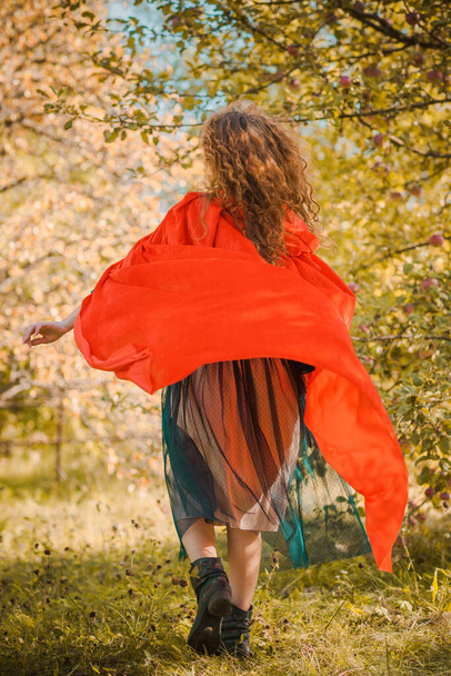 Γυναίκα σε πράσινο βελούδο ρομαντικό φόρεμα και κόκκινη κουκούλα, Απόκριες στυλ για τα κορίτσια, φύση φθινόπωρο στο παρασκήνιο - Φωτογραφία, εικόνα