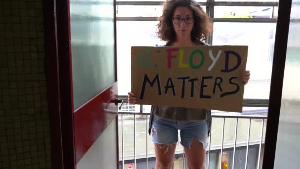 Amerika, VS, New York - juni 2020: protest en manifest van het meisje met bord en tekst "G. Floyd matters" na de moord op George Floyd door de Amerikaanse politie - racisme en sociaal geweld - Video