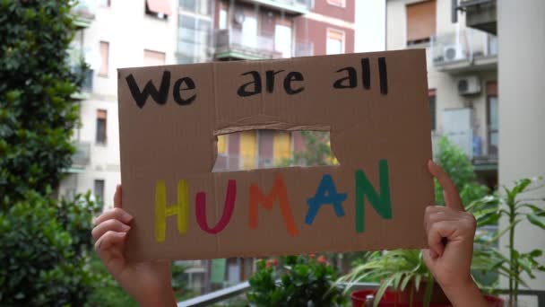 América, EUA - branco latino menina segurando sinal "Somos todos humanos" protesto e manifesto. Conceito de racismo e violência social   - Filmagem, Vídeo