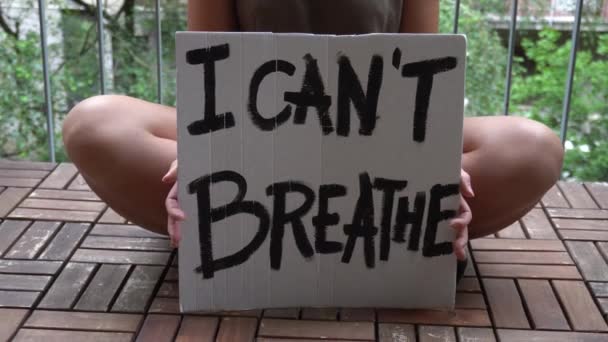 America, USA - La ragazza latina bianca che tiene il cartello "Non riesco a respirare" protesta e manifesta. Concetto di razzismo e violenza sociale  - Filmati, video