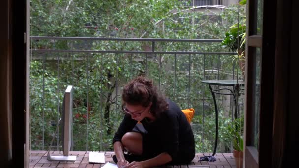 Beyaz kız evde dizüstü bilgisayarla balkonda koruyucu maske takarak çalışıyor. 19 numaralı Coronavirus küresel salgını sırasında zeki bir çalışma. - Video, Çekim