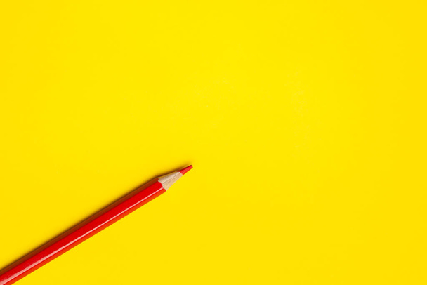 diagonal red sharp wooden pencil on a bright yellow background, isolated, copy space, mock up - Photo, Image