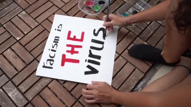 Amerika Birleşik Devletleri - "Irkçılık virüstür" yazan beyaz Latin kız protesto ve bildiri tutuyor. Irkçılık ve sosyal şiddet kavramı  - Video, Çekim