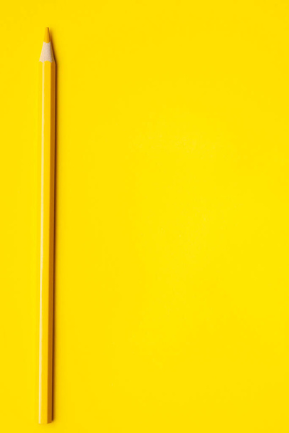 vertical yellow sharp wooden pencil on a bright yellow background, isolated, copy space, mock up - Foto, afbeelding