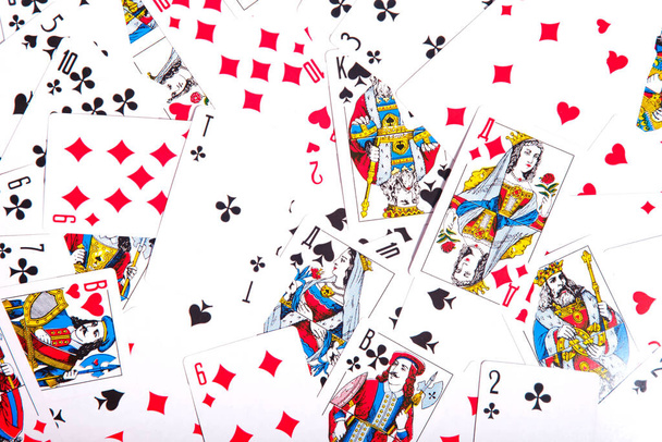 Playing cards are scattered on table. Background of scattered deck of cards filling entire space of image. Top view, close-up. Copyright space for site or logo - Photo, Image