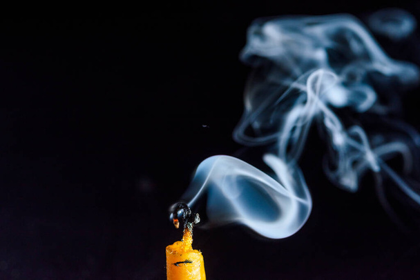 Smoke on a dying candle against a dark background. - Φωτογραφία, εικόνα