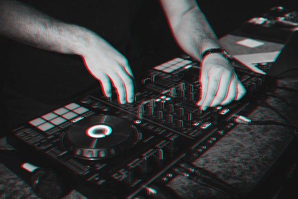 DJ χέρια μείγμα μουσικής σε ένα πίνακα μίξης σε ένα νυχτερινό κέντρο διασκέδασης - Φωτογραφία, εικόνα