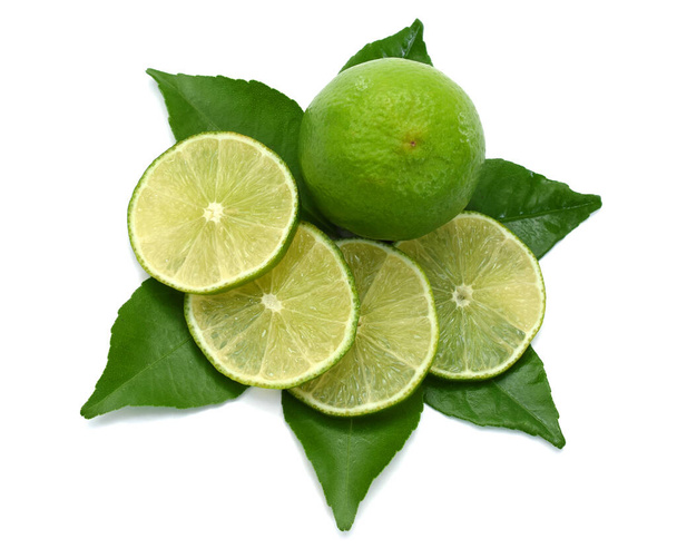 Agrumes frais citron vert avec des tranches isolées sur fond blanc - Photo, image