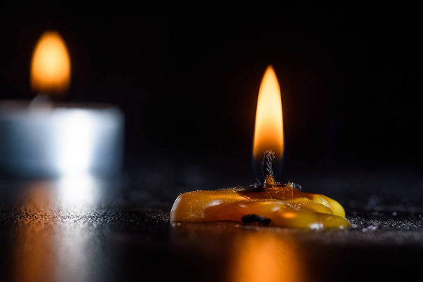 A burning candle against a dark background close-up. - Foto, Imagen