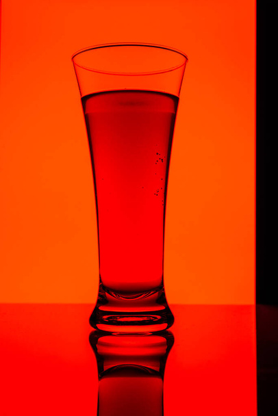 View on glass with red liquid on a red background  - Foto, Imagem
