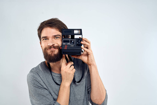 αρσενικό φωτογράφος κρατώντας φωτογραφική μηχανή επαγγελματικό φακό δημιουργικό στούντιο εργασίας φως φόντο - Φωτογραφία, εικόνα