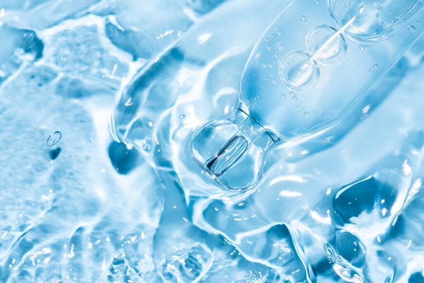 macro de pipeta con líquido y gota sobre fondo azul - Foto, Imagen