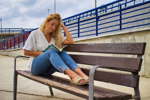 chica leyendo en un banco del parque - Foto, Imagen