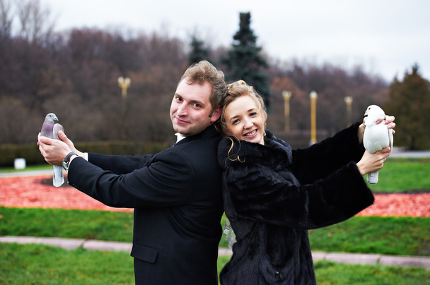 Bride and groom with pigeons on hands - Zdjęcie, obraz