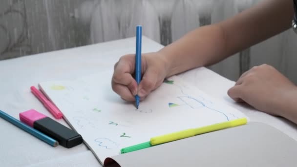 girl in gas mask sits at table, draws illustration with felt pens in album - Filmati, video