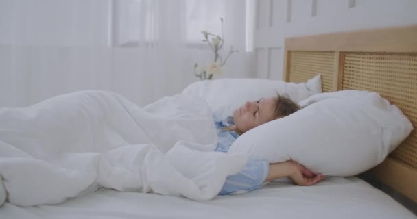 Młoda irytująca kobieta próbująca zasnąć zirytowana przez hałaśliwych sąsiadów, zakrywających uszy poduszką, wściekła studentka, zaburzona hałasem, budzi się w łóżku i cierpi na bezsenność. - Materiał filmowy, wideo