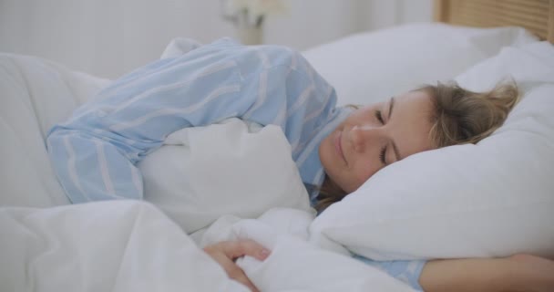 Nuori ärtynyt nainen yrittää nukkua ärsyttää huono meluisa huone naapurit peittävät korvat tyynyllä, vihainen tyttö opiskelija häiritsee kovaa melua ongelma herätä makaa sängyssä kärsivät unettomuudesta - Materiaali, video