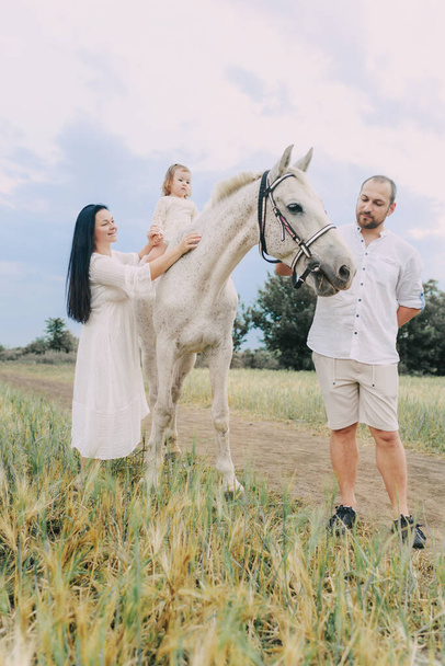 Family in white clothes in a field - Valokuva, kuva