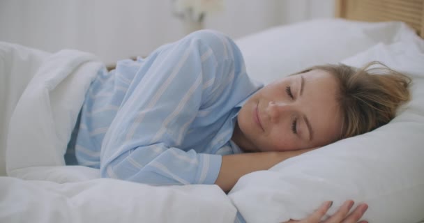 Mladá žena ležící v posteli v ložnici s kostkovaným třes mrazení pocit chladu doma bez problémů ústředního topení v chladném období, nemocná nemocná dívka zabalená v přikrývce s příznaky chřipky - Záběry, video