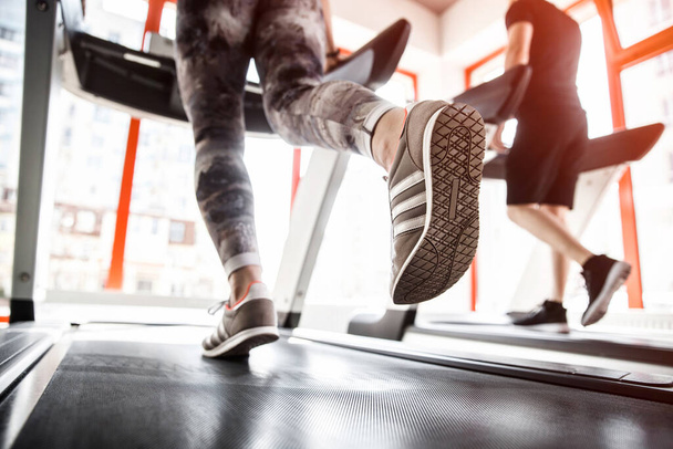 Closeup of a womans legs running on a treadmill. - Foto, afbeelding