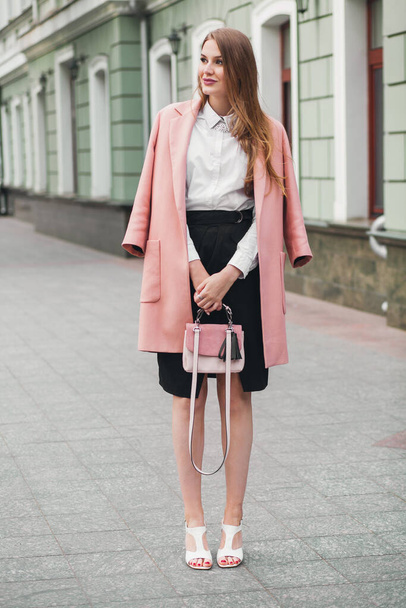 attractive stylish smiling woman walking city street in pink coat spring fashion trend holding purse, elegant style - Fotoğraf, Görsel