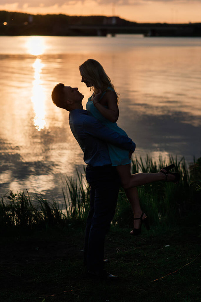 Couple in love back light silhouette at lake orange sunset, romantic. - Fotó, kép