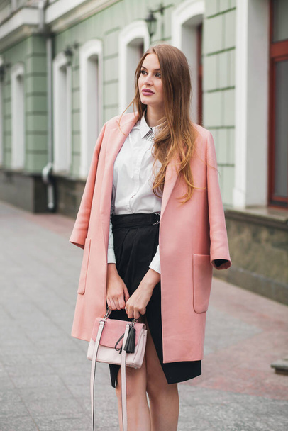 pretty young stylish beautiful woman walking in street, wearing pink coat, purse, white shirt, black skirt, fashion outfit, autumn trend, smiling happy, accessories - Foto, imagen