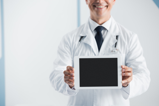 病院で空白の画面とデジタルタブレットを保持医師の作物ビュー  - 写真・画像