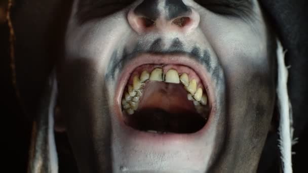 Hombre con esqueleto maquillaje tratando de asustar, abriendo la boca y mostrando sucios dientes negros y la lengua - Imágenes, Vídeo