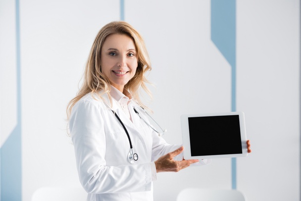 Médico señalando con la mano a la tableta digital en la clínica  - Foto, imagen