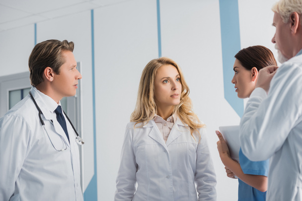 Szelektív fókusz az orvosok és a nővér digitális tabletta beszél a kórházban  - Fotó, kép