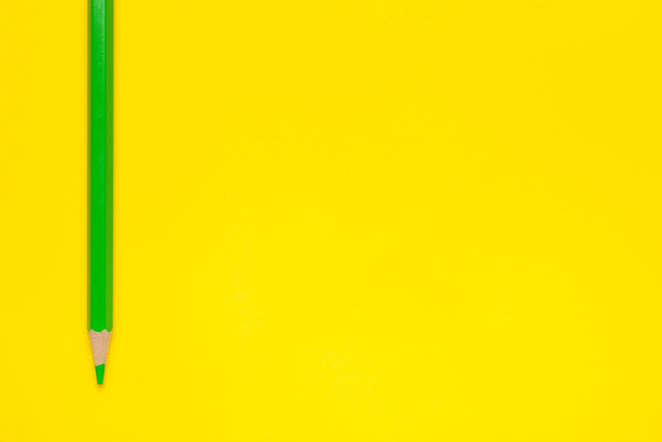 vertical green sharp wooden pencil on a bright yellow background, isolated, copy space, mock up - Φωτογραφία, εικόνα