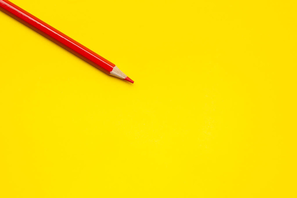 diagonal red sharp wooden pencil on a bright yellow background, isolated, copy space, mock up - Foto, Imagen