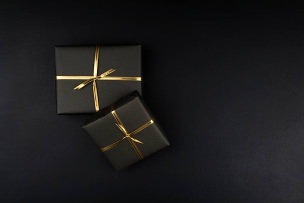 Gift boxes in black packaging on black background, black friday concept - Fotoğraf, Görsel