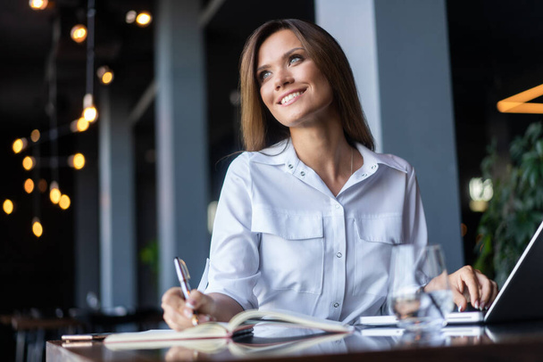 Brunette Business woman working with papers near window in cafe - Foto, Imagen