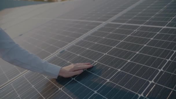 Frau geht in die Nähe von Sonnenkollektoren und berührt Solarzellen. Kostenloser Strom für zu Hause. Nachhaltigkeit des Planeten. Grüne Energie. - Filmmaterial, Video