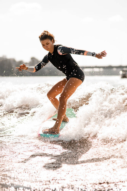 Young woman go in for active water sport with surf style wakeboard - Foto, Imagen