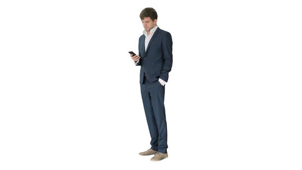 Serious businessman looking at his phone on white background. - Foto, imagen